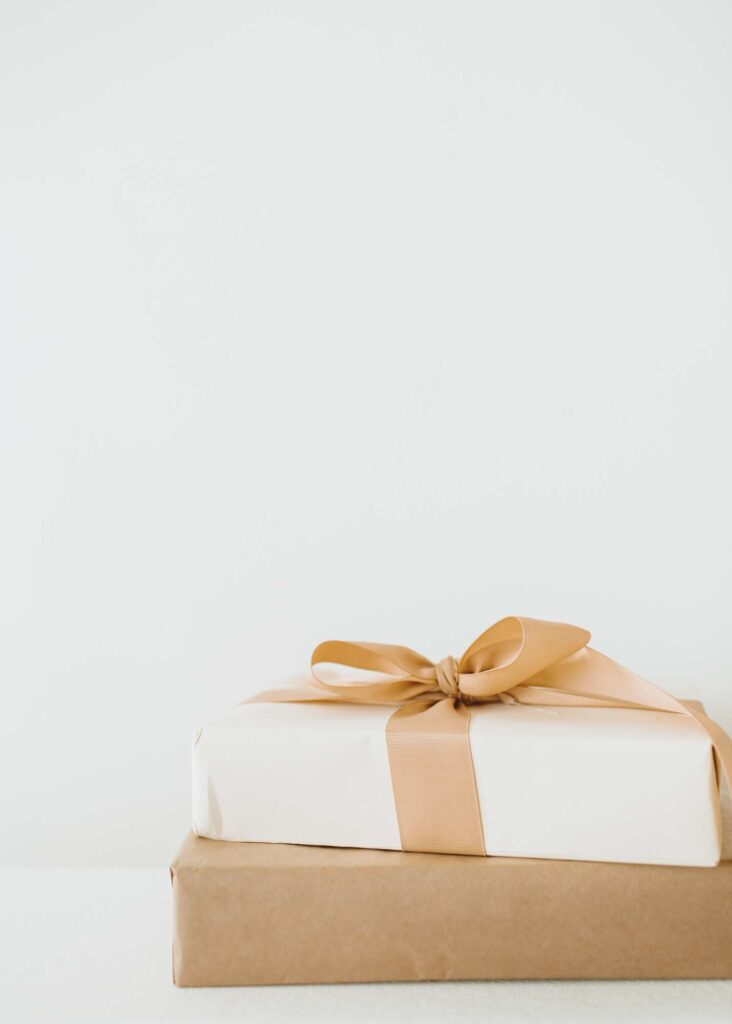 2 gifts wrapped in neutral colors with a tan bow. These represent the gifts that small business owners should use to spoil their ideal clients to make them feel special 